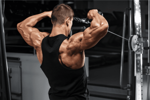 Uomo in palestra che esegue le alzate frontali al cavo alto