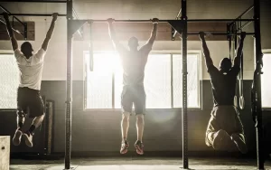 ragazzi in palestra che fanno trazioni alla sbarra